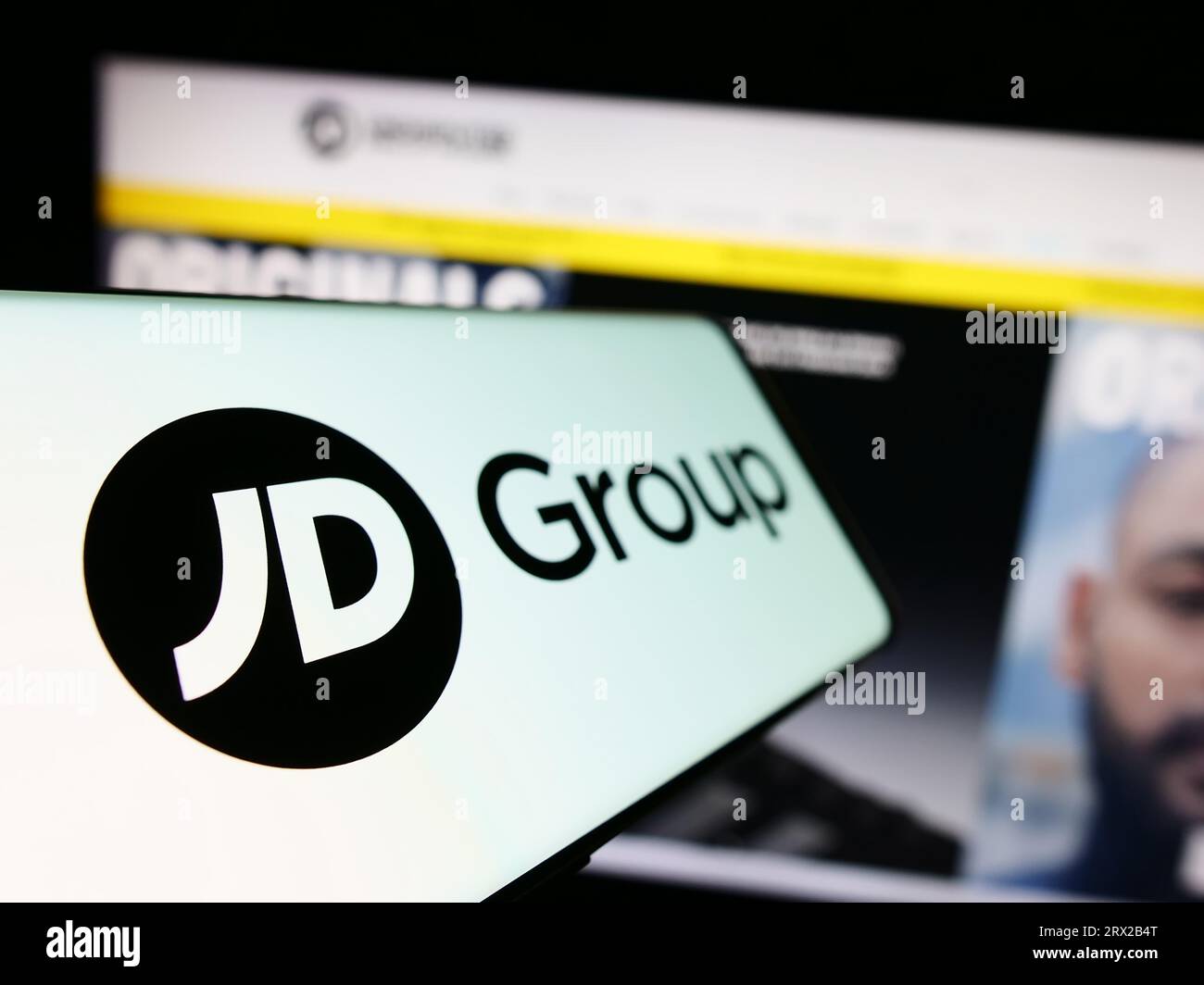 Smartphone mit Logo des britischen Einzelhandelsunternehmens JD Sports Fashion plc auf dem Bildschirm vor der Business-Website. Fokus auf der linken Seite des Telefondisplays. Stockfoto