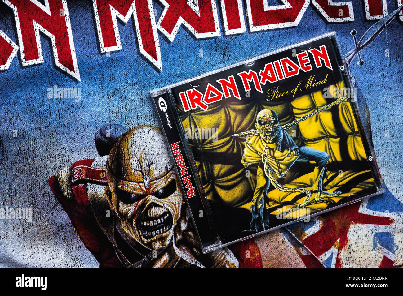 Nahaufnahme des Covers der Piece of Mind-CD von Iron Maiden auf einem T-Shirt mit dem Iron Maiden-Logo. Iron Maiden ist eine britische Heavy-Metal-Band Stockfoto