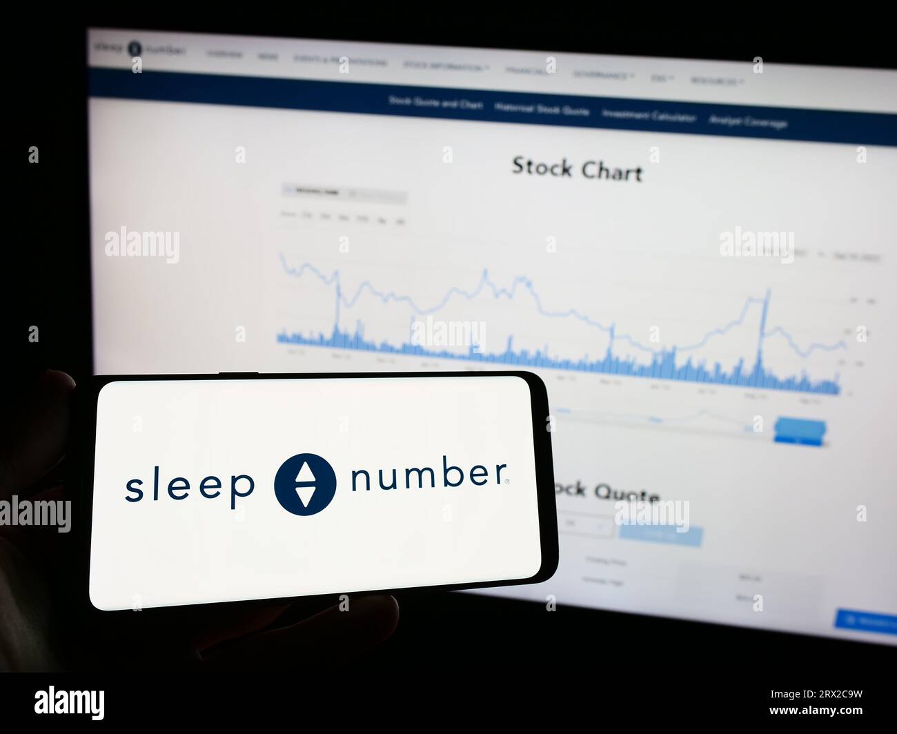 Person, die ein Mobiltelefon mit dem Logo des amerikanischen Bettenunternehmens Sleep Number Corporation auf dem Bildschirm vor der Webseite hält. Konzentrieren Sie sich auf das Display des Telefons. Stockfoto