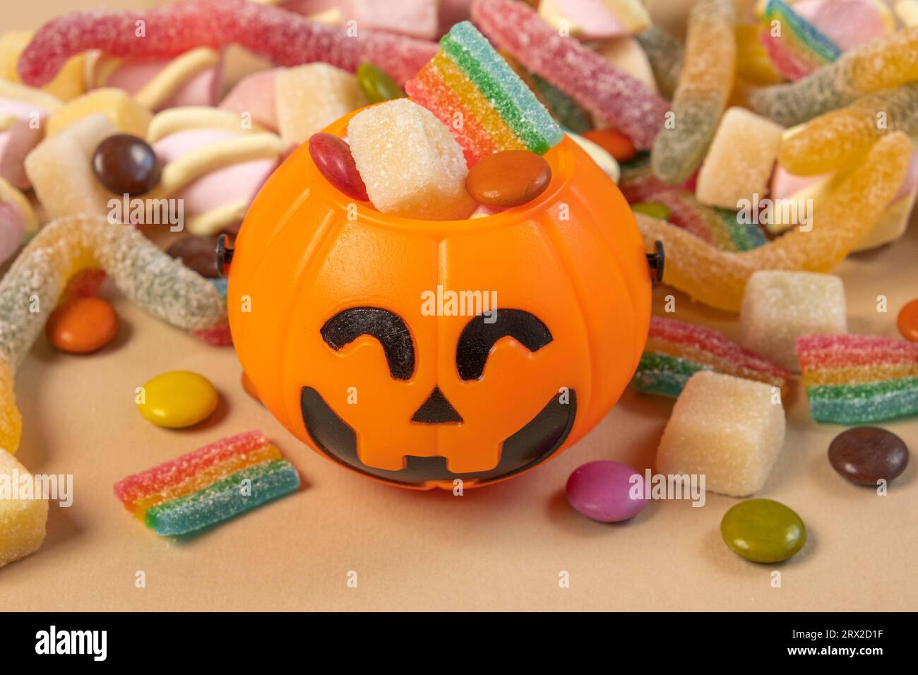 Halloween Jelly Beans. Happy Halloween Party Border Beige Hintergrund. Banner Für Ästhetisches Zubehör. Gruseliger Orangener Kürbis-Süßigkeiteneimer. Moderner Urlaub Stockfoto