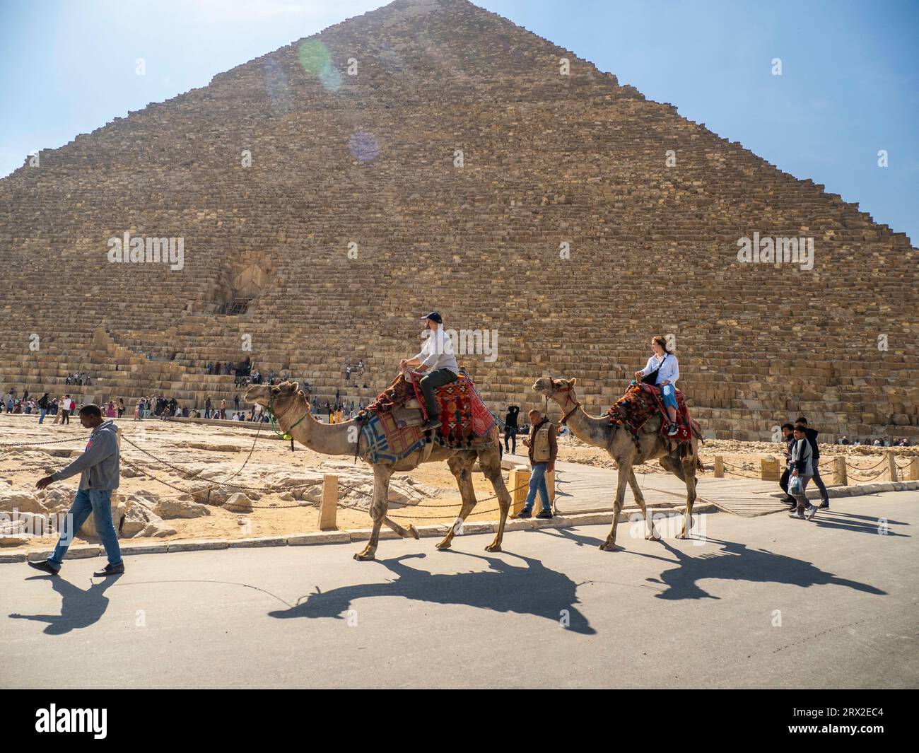 Tourist auf einem Kamelritt vor der Großen Pyramide von Gizeh, dem ältesten der sieben Weltwunder, in der Nähe von Kairo, Ägypten Stockfoto