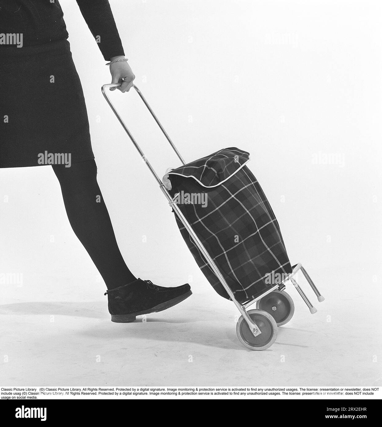 Shopping in den 1960er Jahren Eine junge Dame benutzt ihren Einkaufswagen, um ihre Lebensmittel zu transportieren. Eine Neuheit, die ursprünglich aus den USA kam. Schweden 1966 Kristoffersson ref CY18-7 Stockfoto