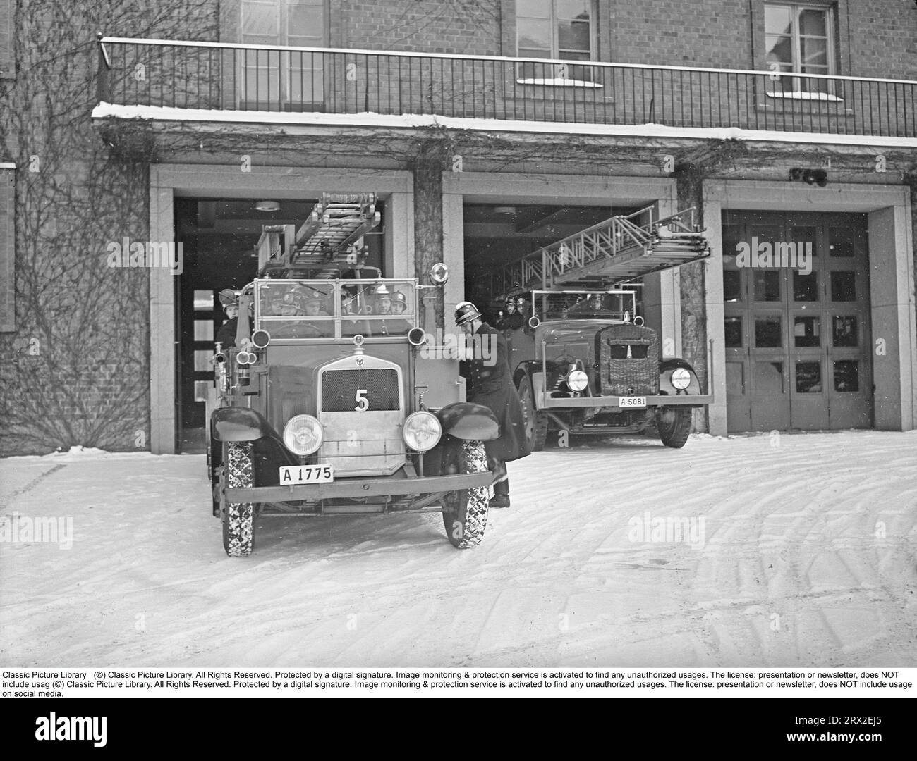 In den 1940er Jahren stürzen Feuerwehrleute der Kungsholmen-Feuerwehr in Stockholm in ihren offenen Feuerwehrauto. In Feueruniformen und Helmen mit Emblemen gekleidet, fahren sie aus der Feuerwache. Das Löschfahrzeug ist mit Leitern und einer Pumpenanlage ausgestattet. Eine Messingglocke ertönt während des Anrufs. Februar 1940. Kristoffersson, Ref. 57-4 Stockfoto