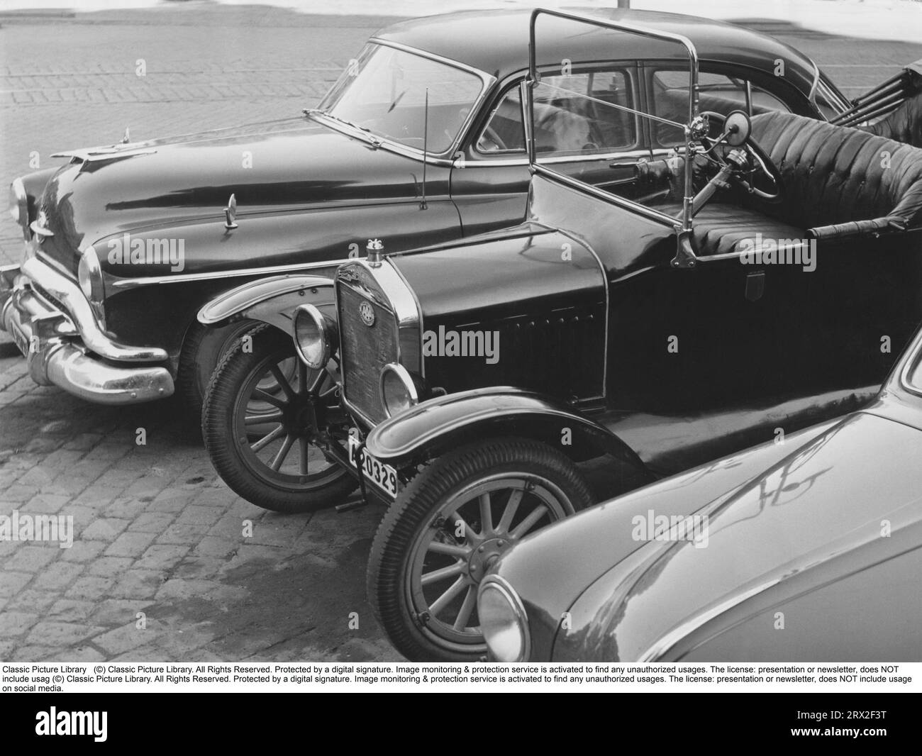 In den 1950er Jahren Autos stehen nebeneinander und stammen aus verschiedenen Epochen. Ein amerikanisches Oldsmobile, Modell CA 1951-1952 und ein Modell T Ford. Schweden 1957 Stockfoto
