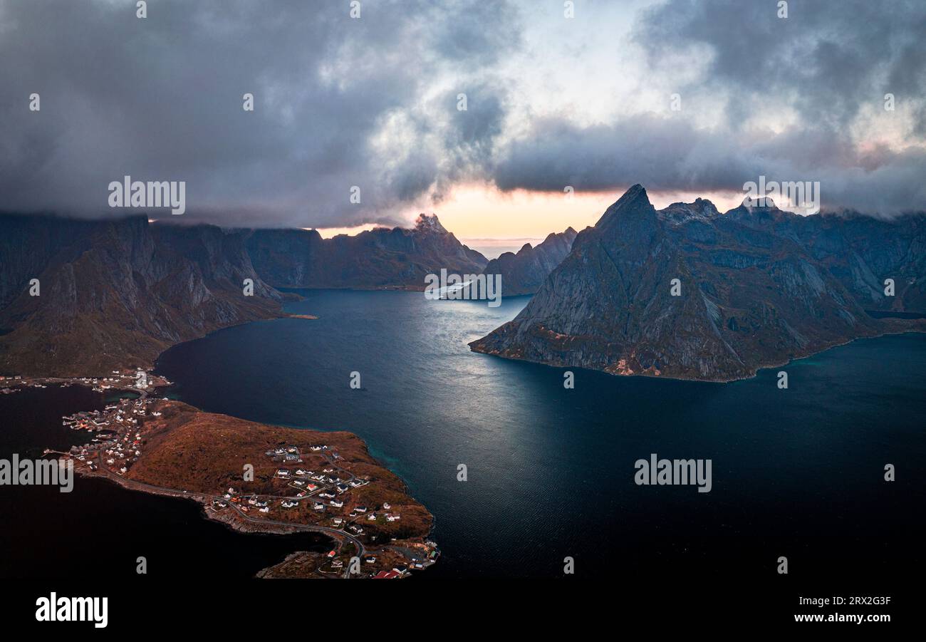 Sturmwolken bei Sonnenuntergang über majestätischen Bergen entlang eines Fjords, Blick aus der Luft, reine Bay, Lofoten-Inseln, Nordland, Norwegen, Skandinavien, Europa Stockfoto