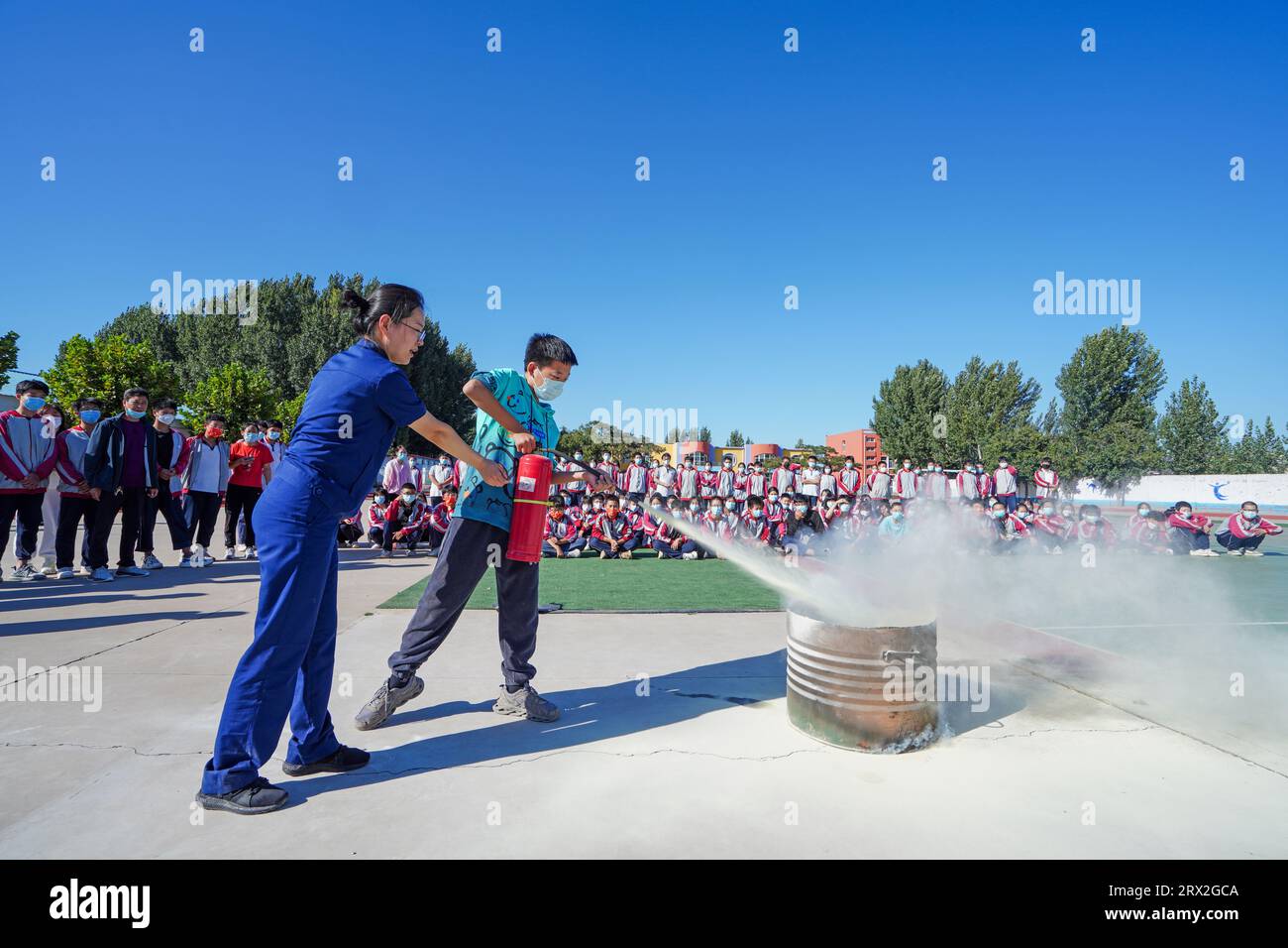 Luannan County, China - 23. September 2022: Feuerwehrmänner führen die Schüler zu ersten Brandbekämpfungsmaßnahmen auf dem Campus in Nordchina Stockfoto