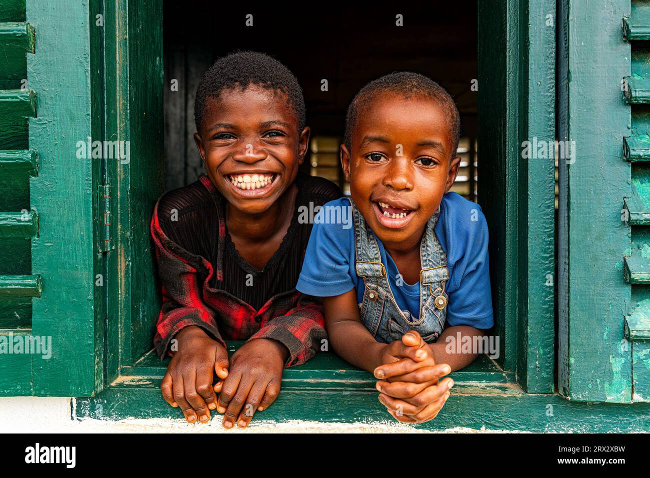 Junge Schulkinder, die aus einem Fenster schauen, Ciudad de la Paz, Rio Muni, Äquatorialguinea, Afrika Stockfoto