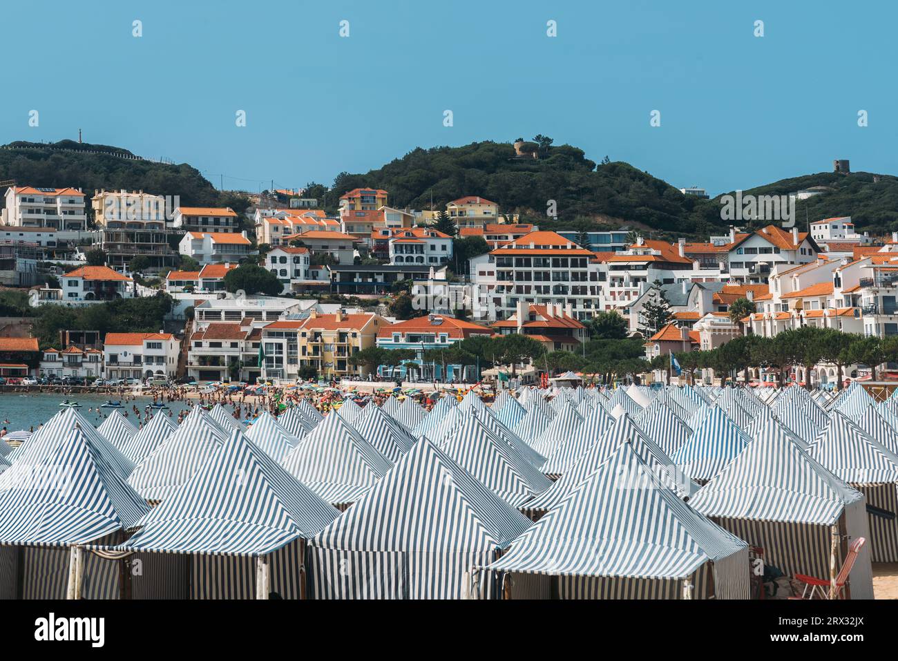 Blick auf grüne Hütten am Strand Sao Martinho do Porto, einem breiten weißen Sandstrand, umgeben von Dünen in einer abgelegenen Bucht, die bei Familien beliebt ist, Oeste, Portugal Stockfoto
