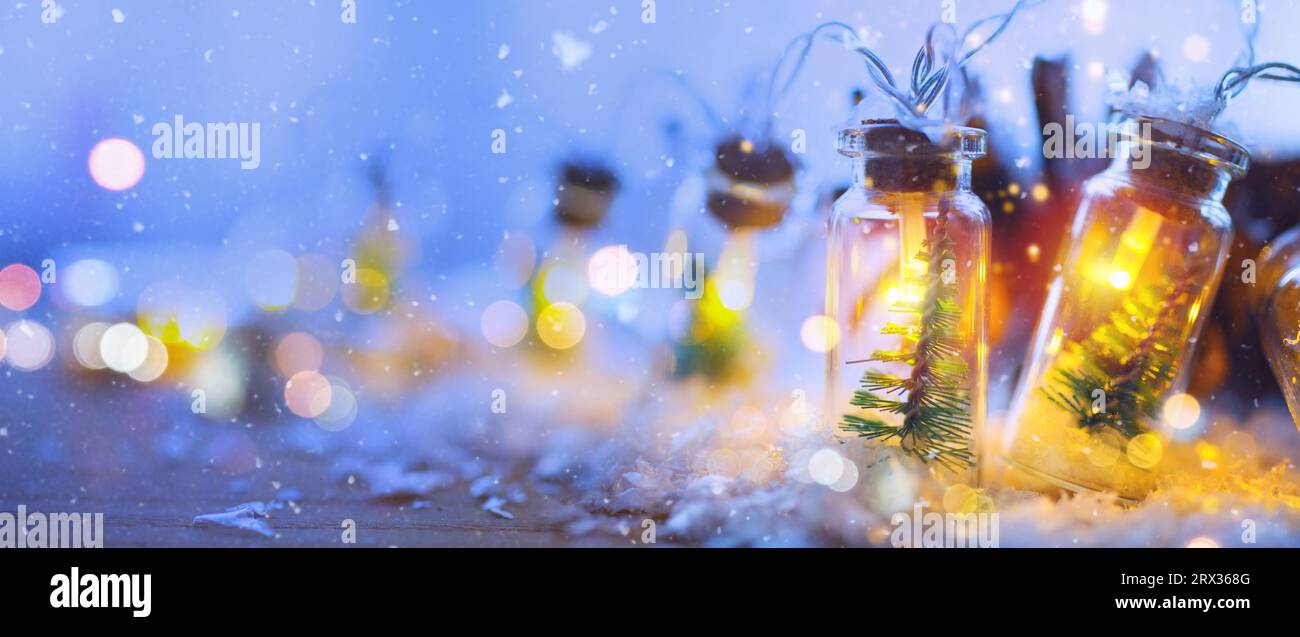 Weihnachtsbeleuchtung und Begrüßungskonzept - bokeh-Lichter mit weihnachtlicher Girlande auf hellblauem Hintergrund Stockfoto