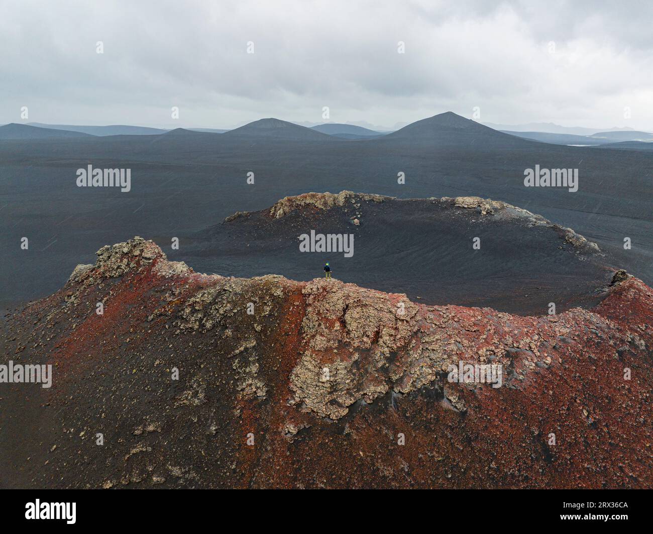 Ein Mensch genießt die wunderschöne Landschaft von der Mündung des alten Vulkans, Highlands, Island, Polarregionen Stockfoto