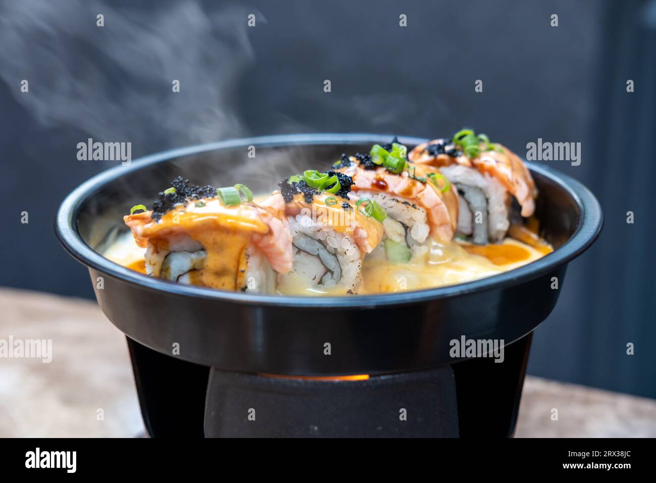 Set mit Salmon Sushi-Rolle auf heißer Pfanne Stockfoto