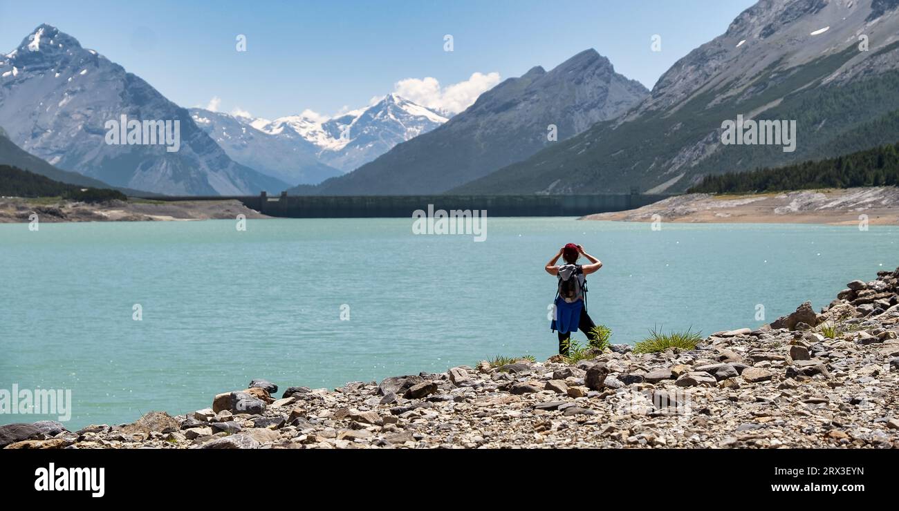 Junge Frau, die den künstlichen See und die Wasserbecken betrachtet. Cancano-See und der obere San Giacomo-See auf etwa 1900 Metern über dem Meeresspiegel in der S Stockfoto