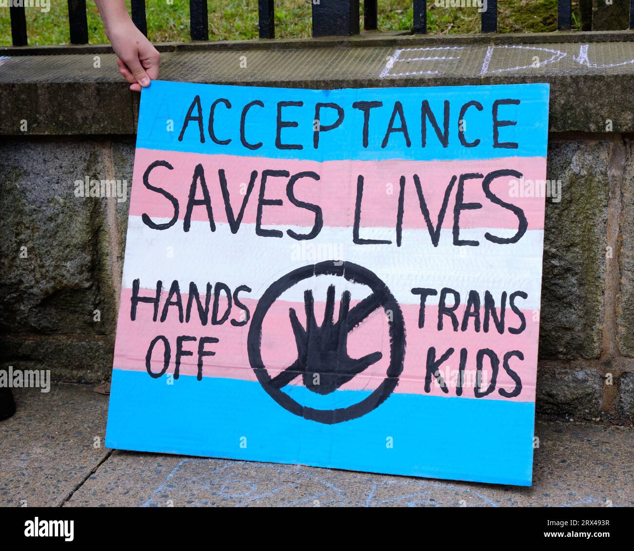 Schild: „Akzeptanz rettet Leben Hände weg von Trans Kid“, gehalten von Pro LGBTQ+-Gegenprotestierer bei Anti-Trans-Kundgebung Stockfoto
