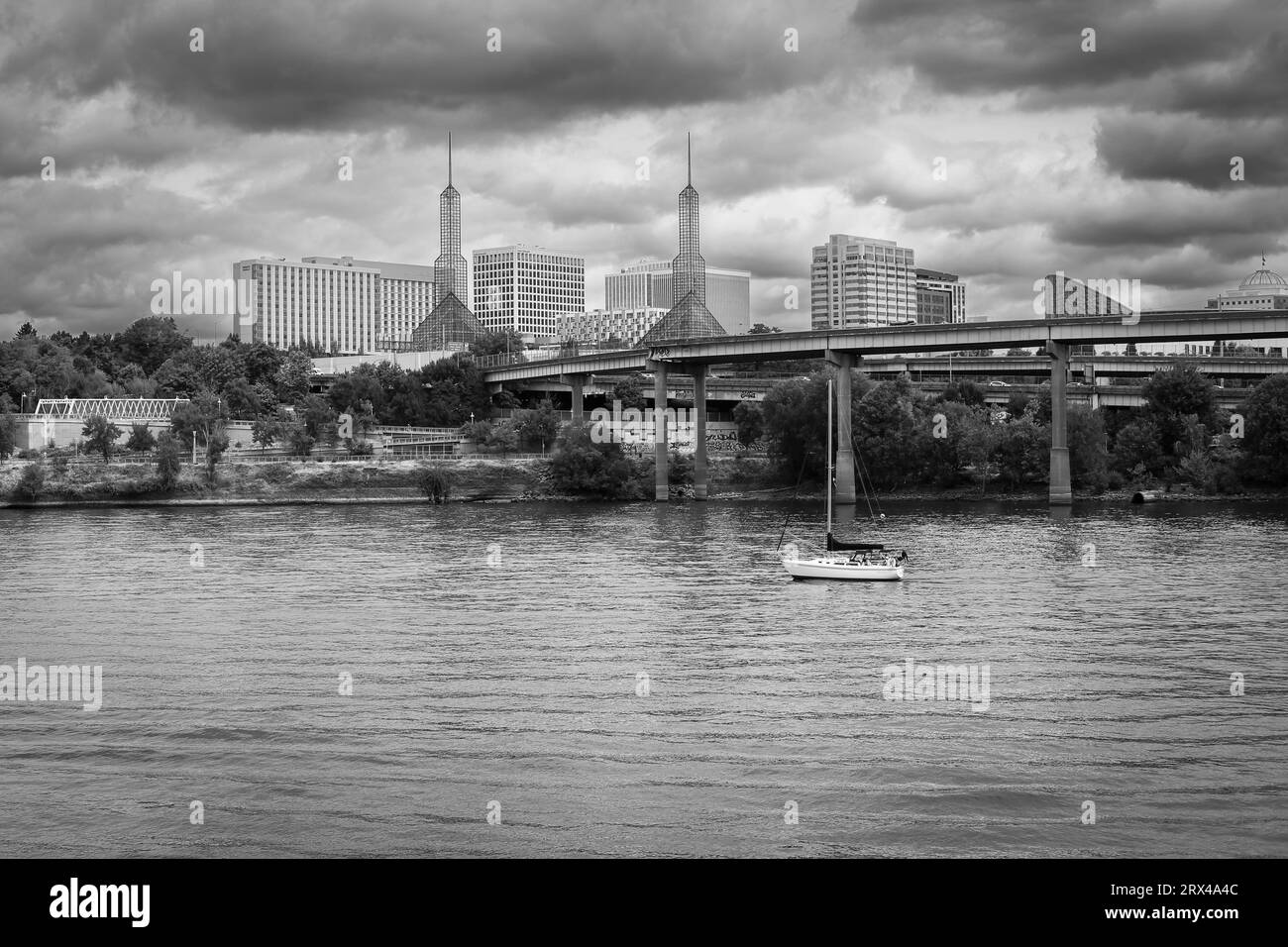 Schwarz-weiß-Bild eines Segelbootes auf dem Willamette River mit dem Oregon Convention Center im Hintergrund Stockfoto