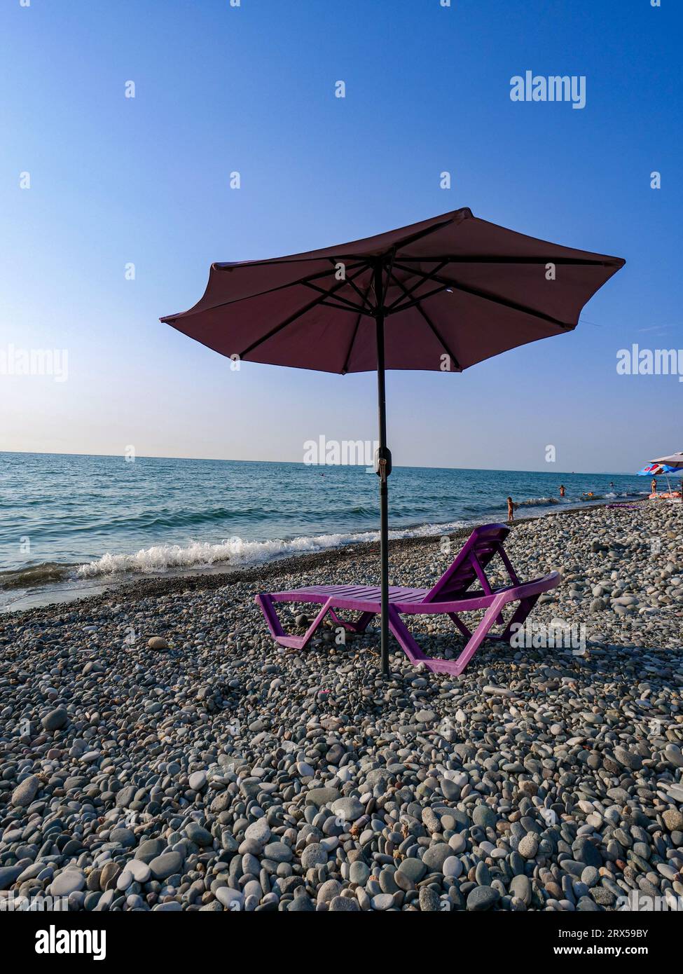 Sonnenliege und Sonnenschirm an einem Steinstrand, Schwarzes Meer Stockfoto