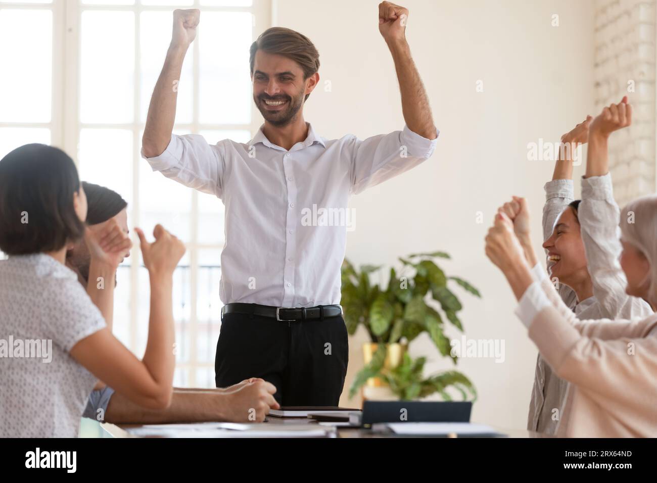 Erfolgreicher Firmeninhaber und Mitarbeiter feiern den Unternehmenssieg Stockfoto