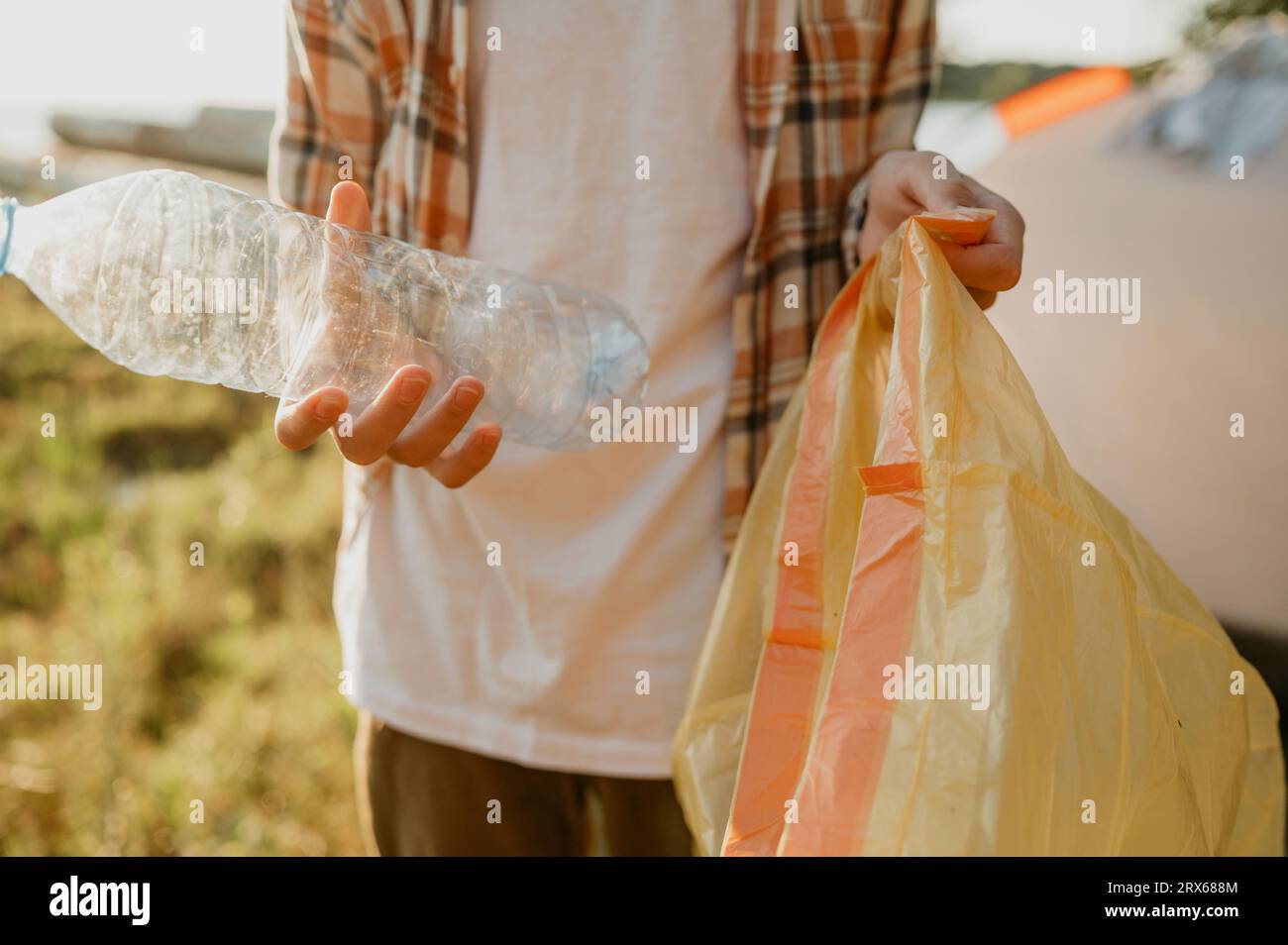 Teenager, der Flaschen in Plastiktüten sammelt Stockfoto