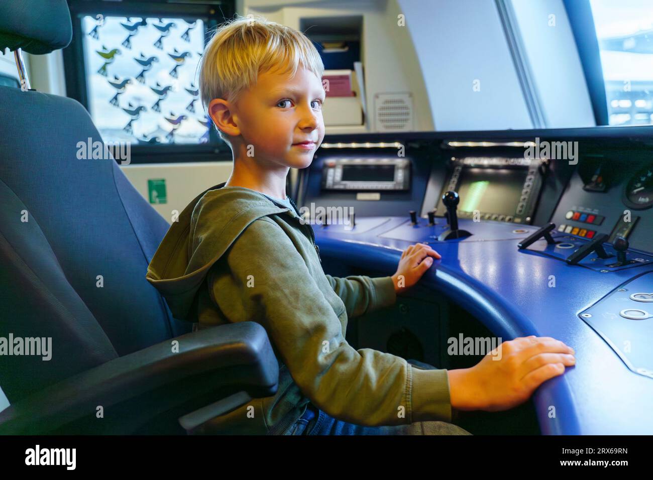 Lächelnder Junge, der im Cockpit der Zugmaschine sitzt Stockfoto