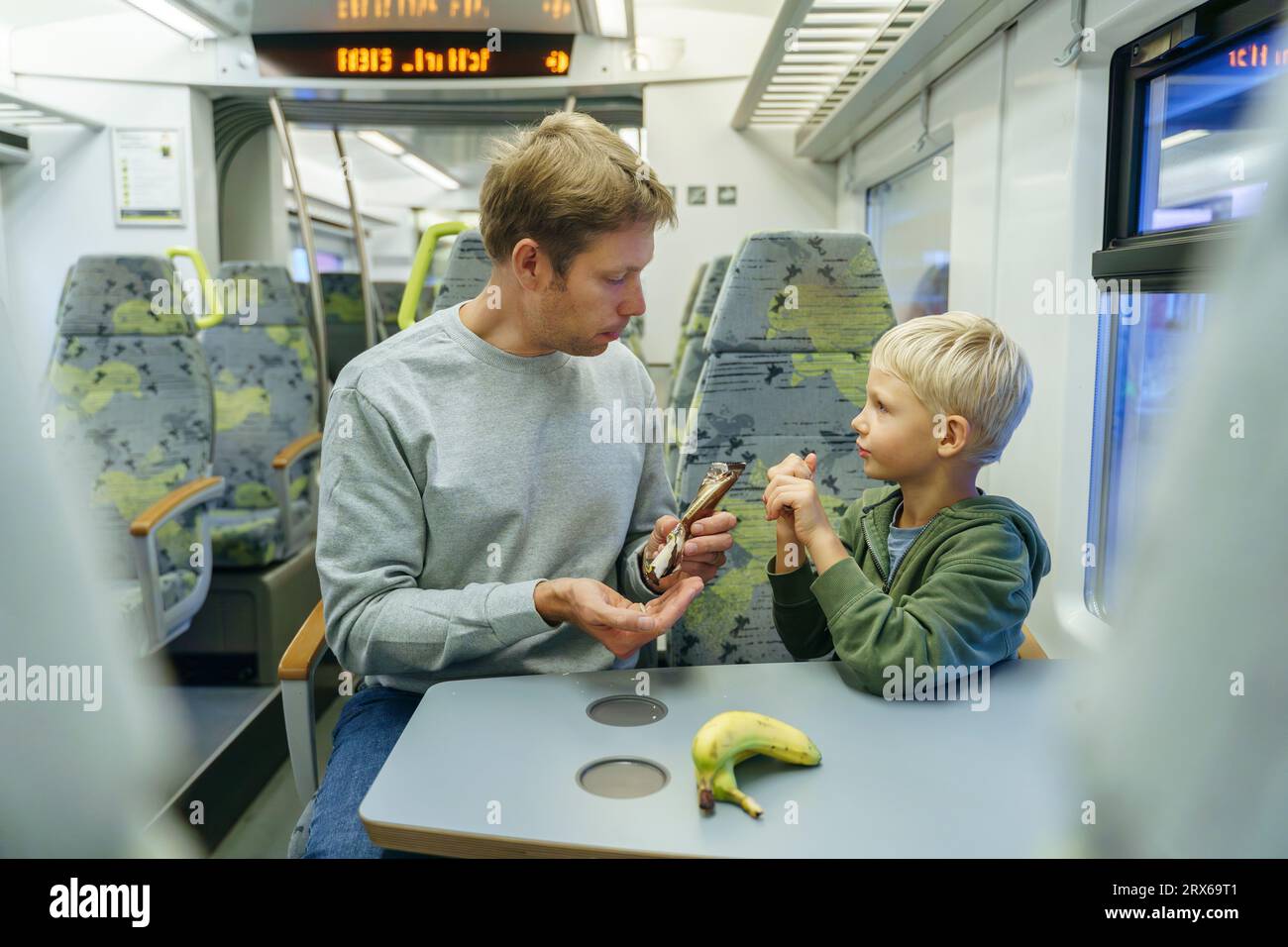 Vater und Sohn haben Banane im Zug Stockfoto