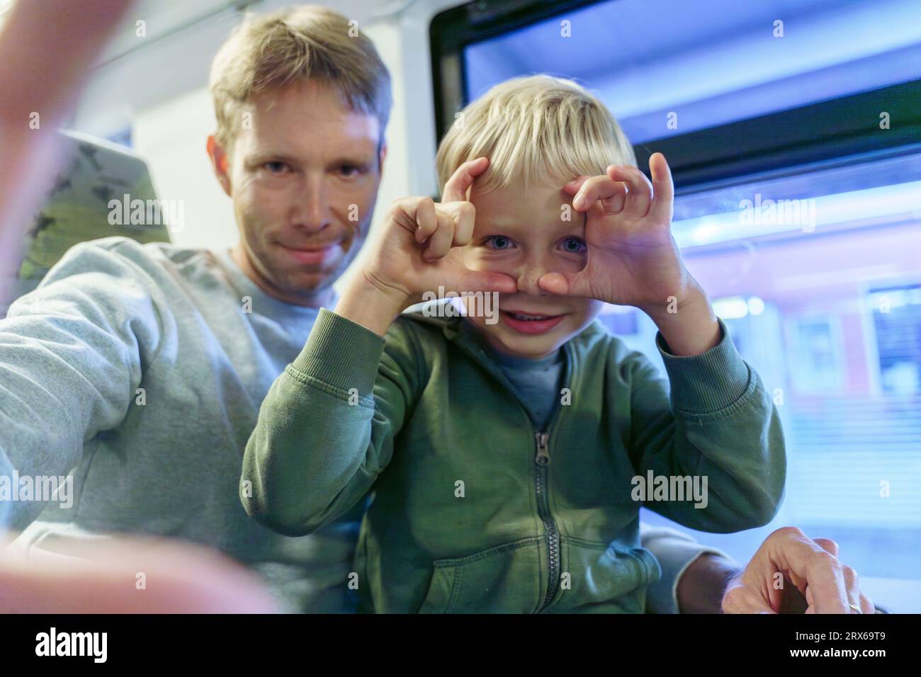 Lächelnder Mann, der Selfie mit dem Sohn im Zug macht Stockfoto