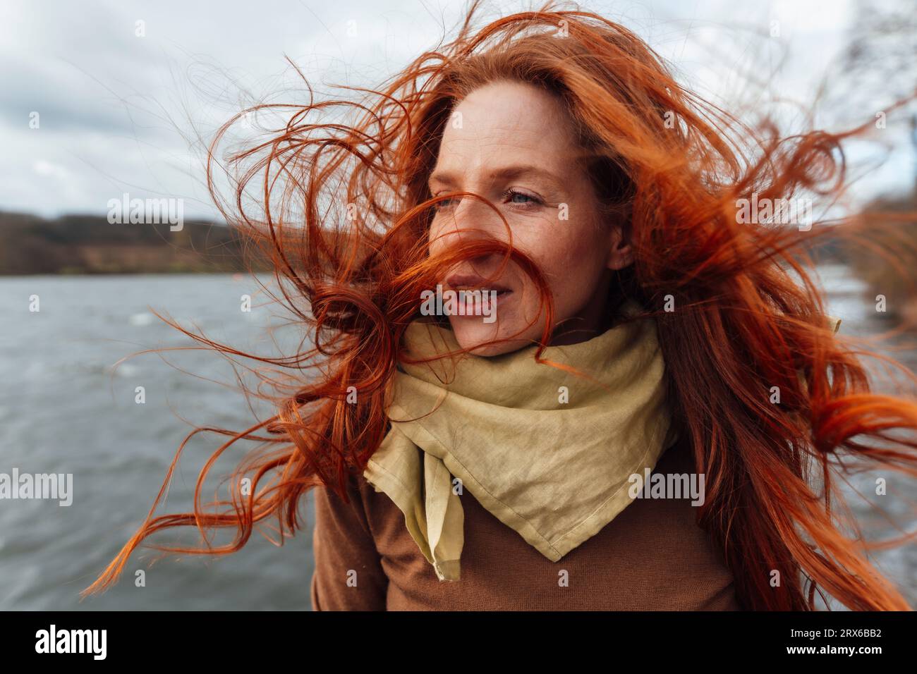 Rothaarige Frau mit im Wind wehenden Haaren Stockfoto
