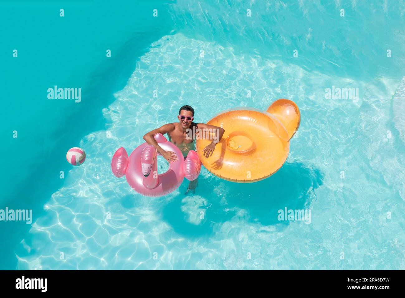 Lächelnder Mann mit aufblasbaren Schwimmern im Pool Stockfoto