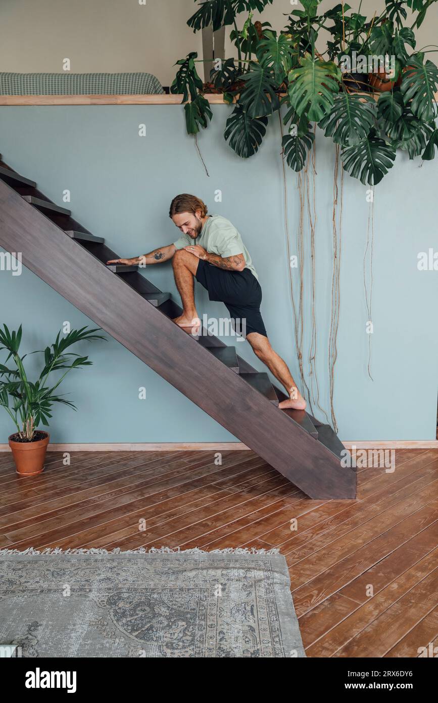 Junger Mann, der zu Hause auf der Treppe trainiert Stockfoto
