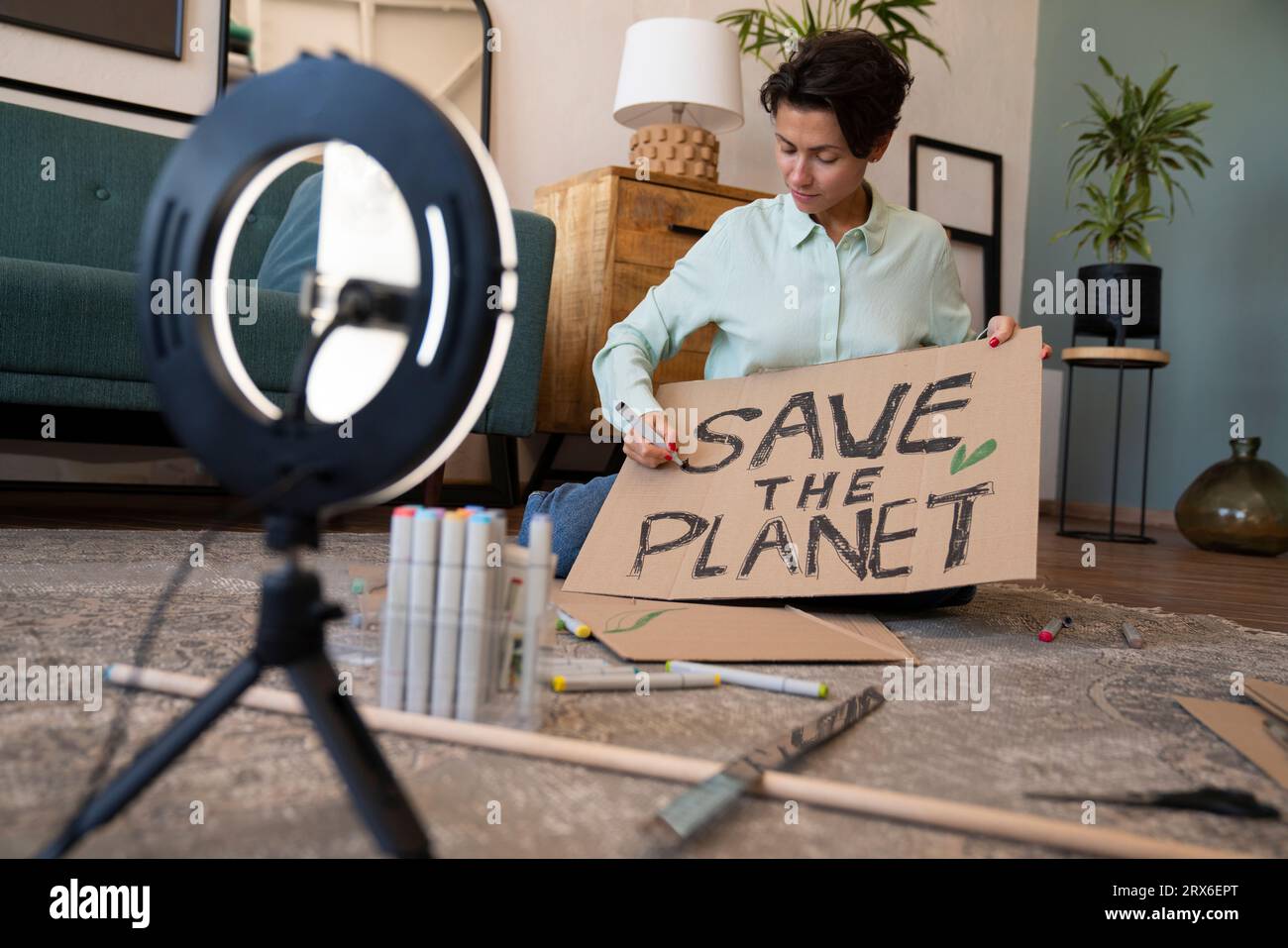 Aktivist mit Umweltplakat-Vlogging zu Hause Stockfoto