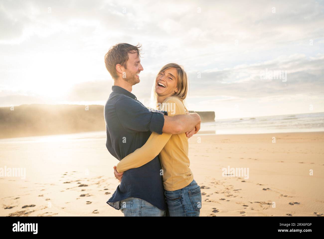 Glückliches Paar, das sich umarmt und den Urlaub am Strand genießt Stockfoto
