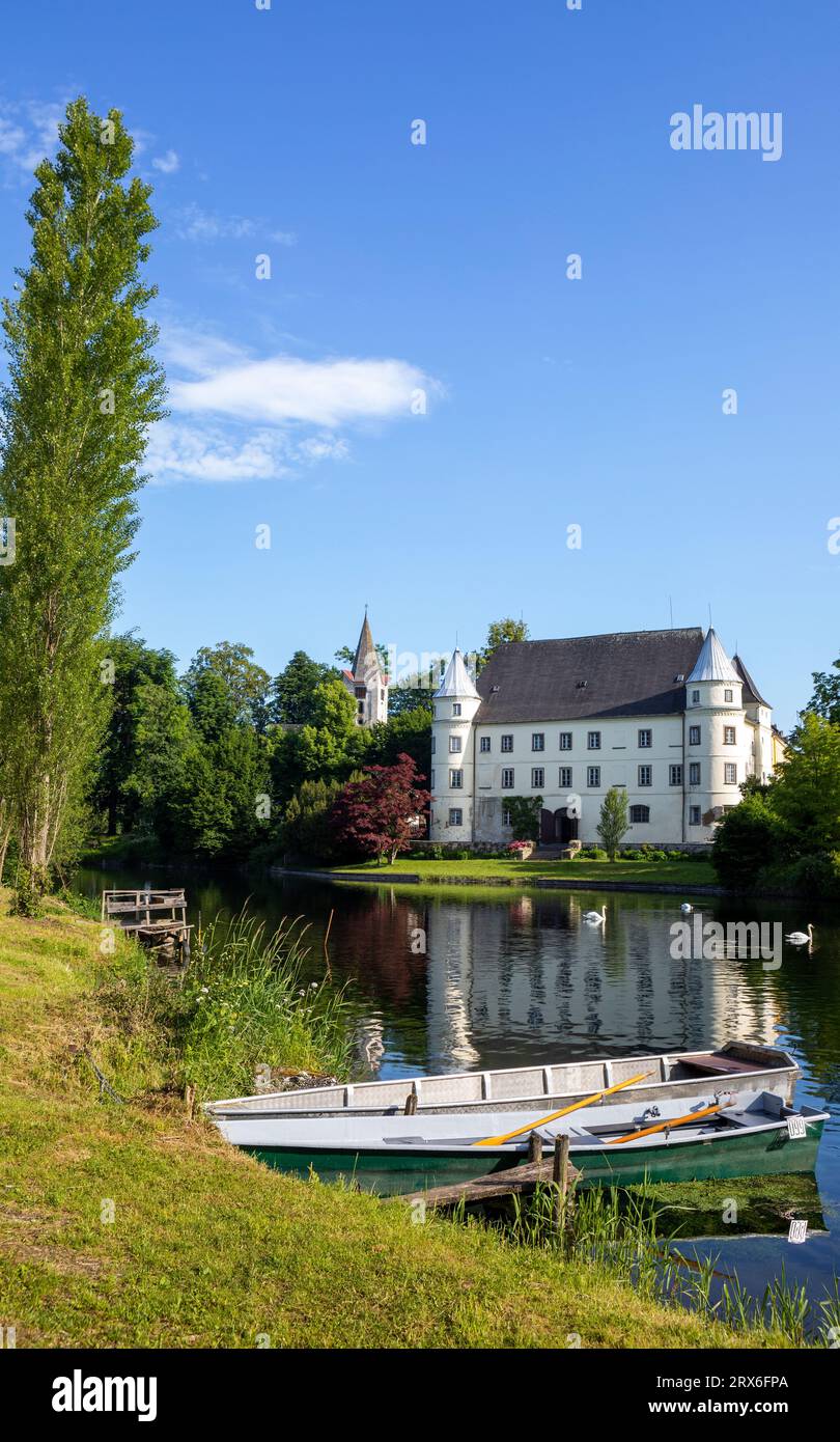 Österreich, Oberösterreich, Sankt Peter am Hart, Ruderboot am Ufer des Flusses Mattig mit Schloss Hagenau im Hintergrund Stockfoto