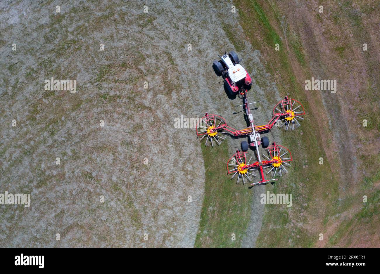 Drohnenansicht des Traktors mit drehbaren Rechen, die Heu drehen Stockfoto