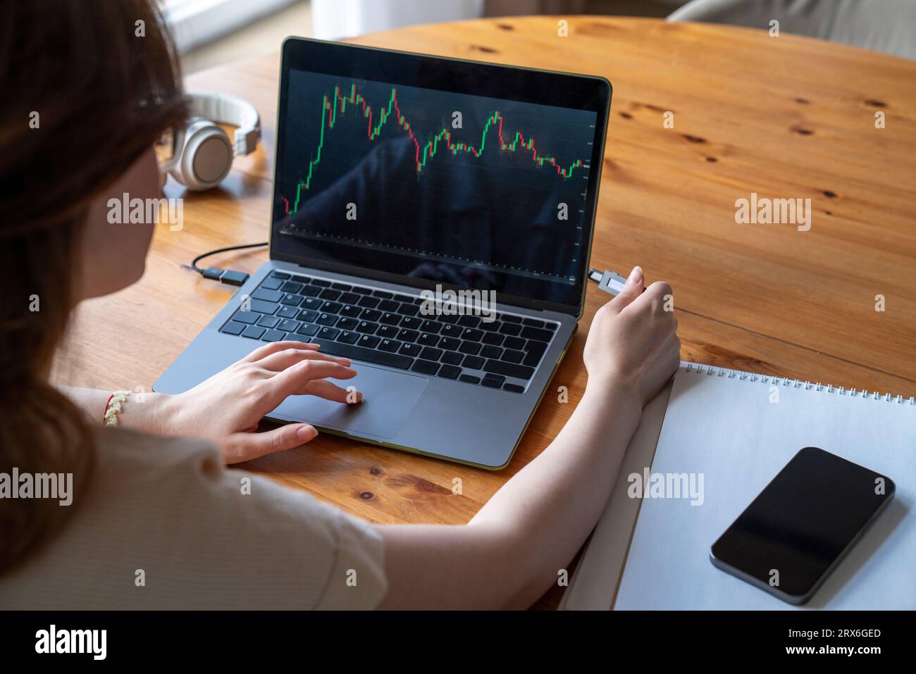 Geschäftsfrau, die zu Hause Investitionsdaten auf dem Laptop analysiert Stockfoto