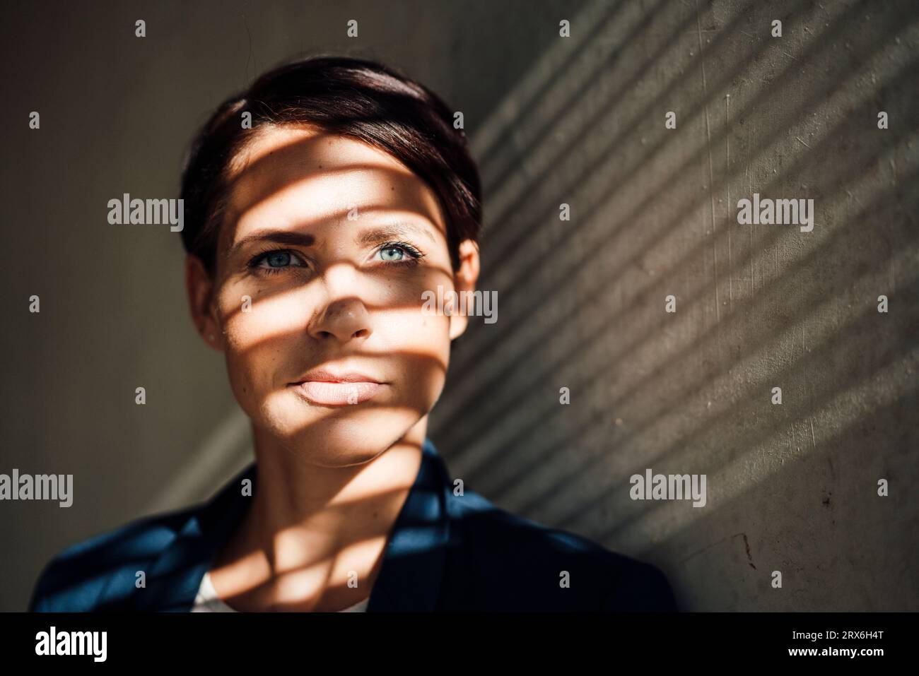 Geschäftsfrau mit Schatten vor der Wand Stockfoto