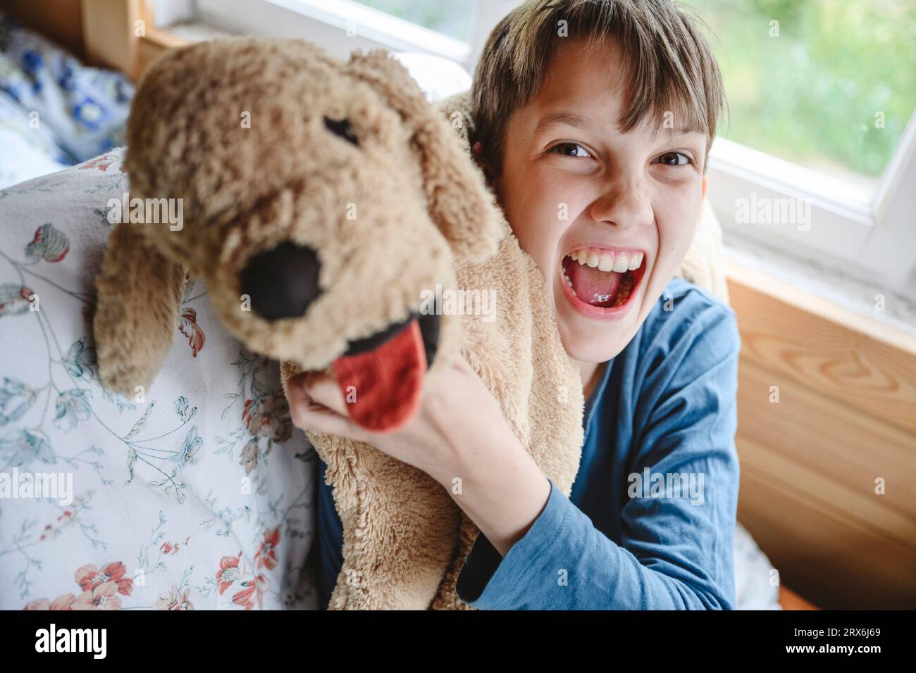 Verspielter Junge mit Stofftier zu Hause Stockfoto