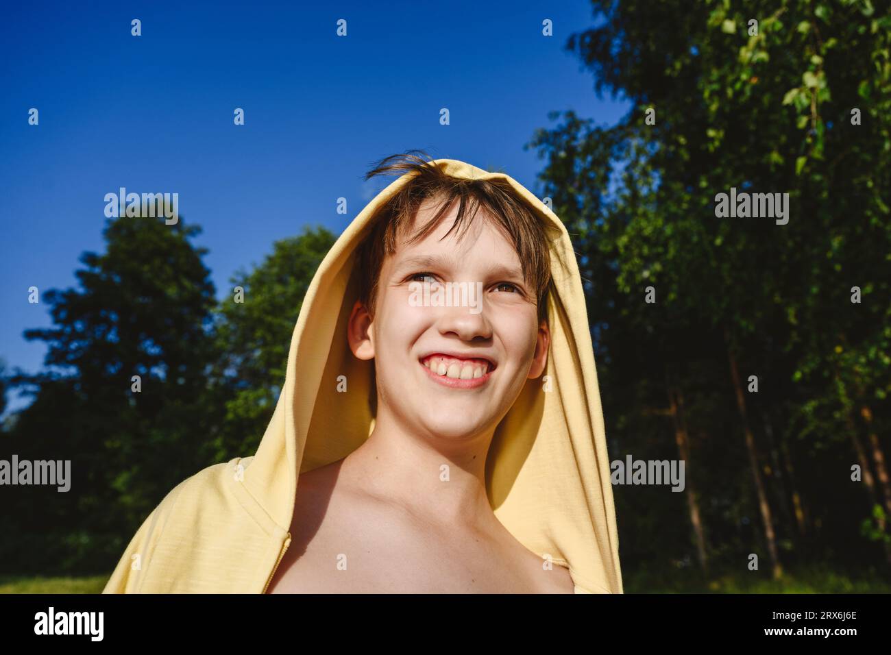 Happy Boy trägt ein gelbes Kapuzenhemd Stockfoto