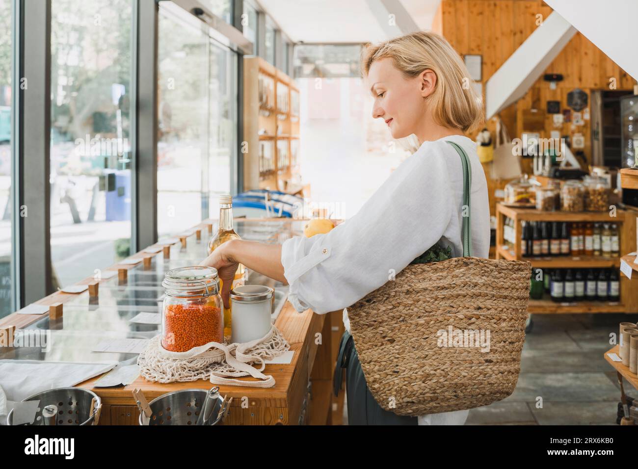 Lächelnde Frau, die Lebensmittel im Laden kauft Stockfoto