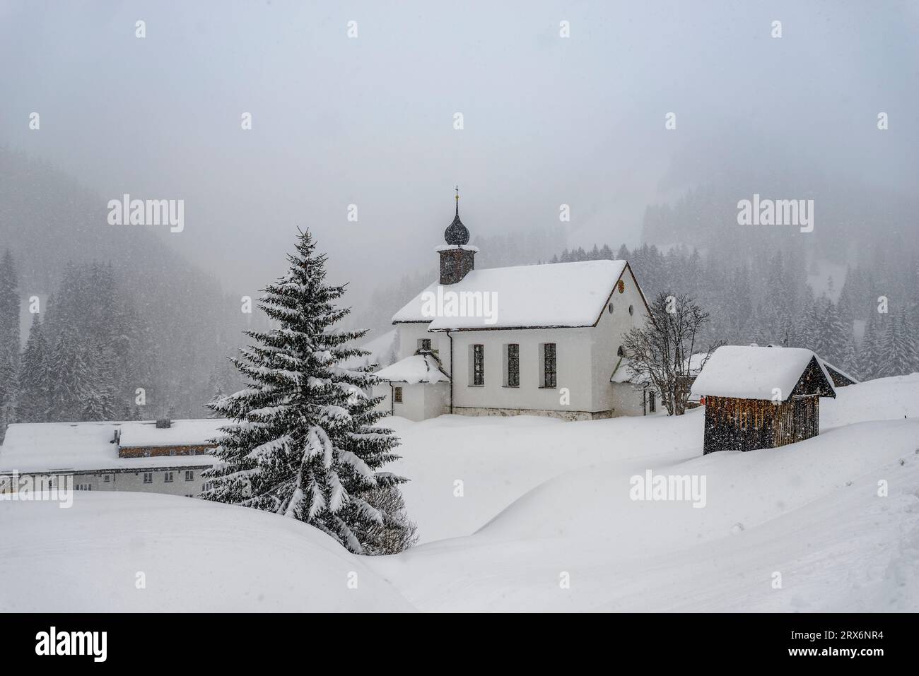 Österreich, Vorarlberg, Baad, Kirche in abgeschiedenem Bergdorf bei nebelndem Wetter Stockfoto