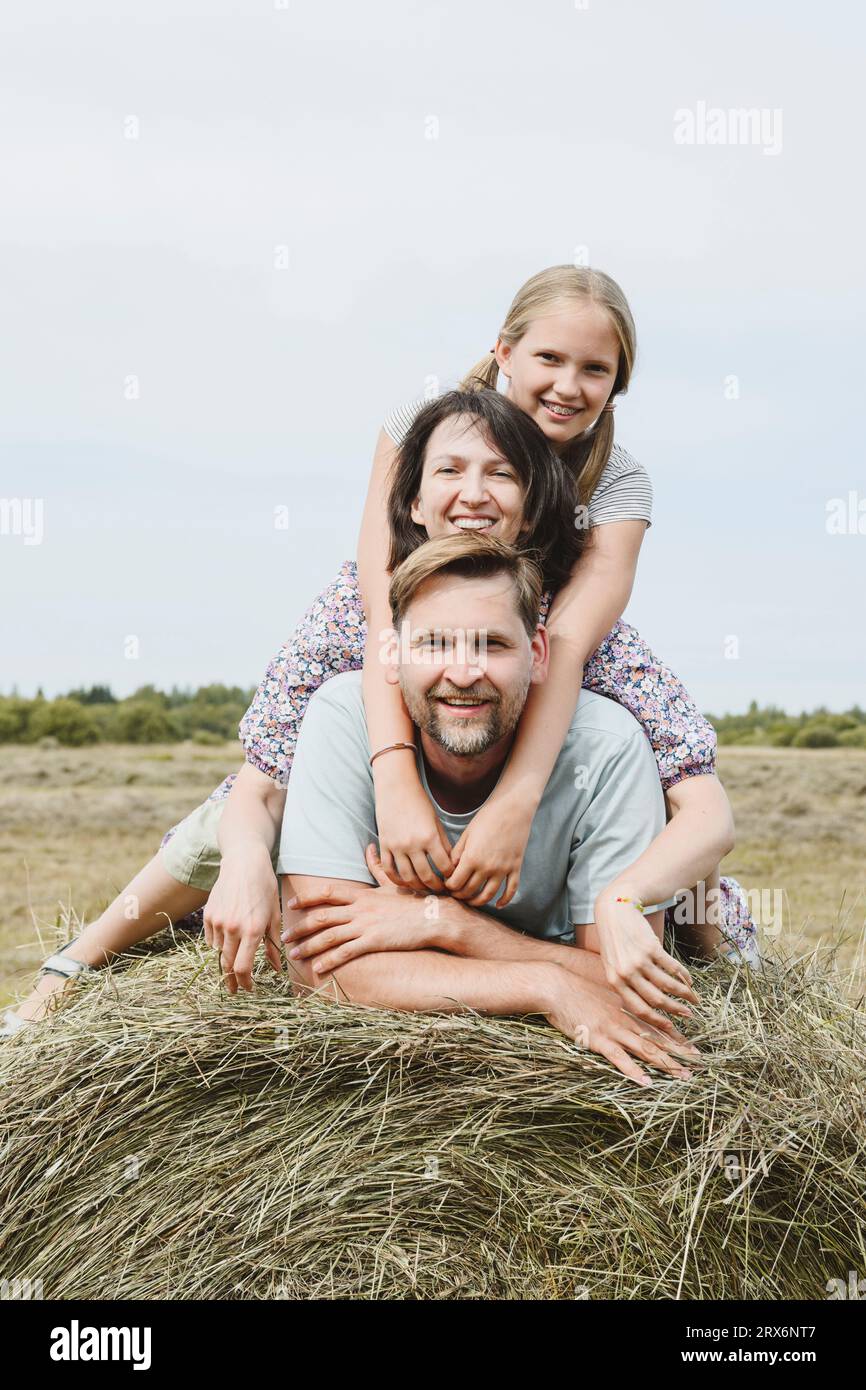 Glückliche Familie auf Heu im Feld Stockfoto