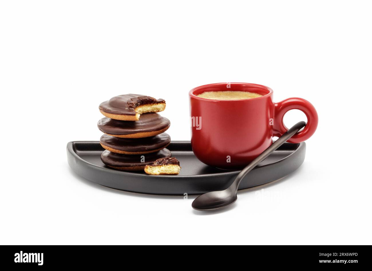 Rote Espresso-Tasse gefüllt mit starkem Kaffee und ein paar Keksen auf schwarzem Teller Stockfoto