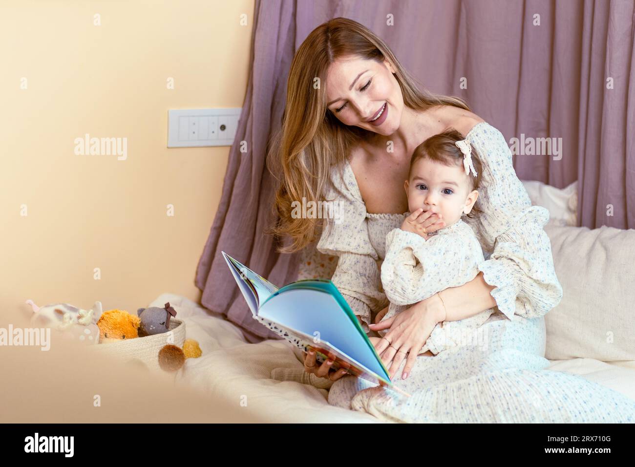 Junge mom liest ihrer kleinen Tochter vor Stockfoto