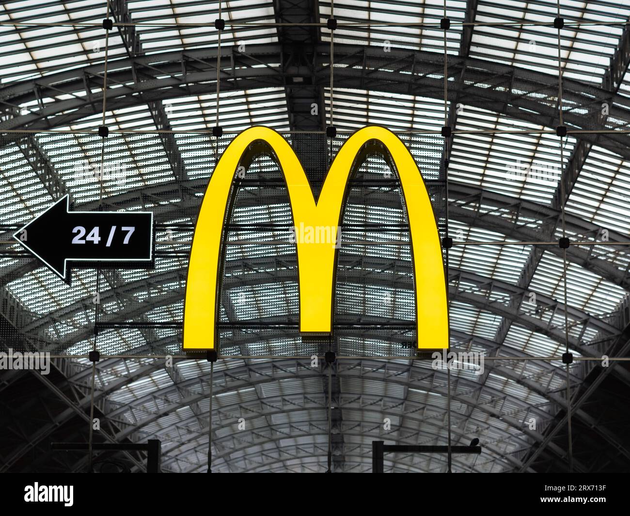 McDonald's Logo Schild namens Golden Arches mit einem Pfeil zum Restaurant. Die amerikanische Fast-Food-Firma ist ein Symbol für den Kapitalismus. Stockfoto