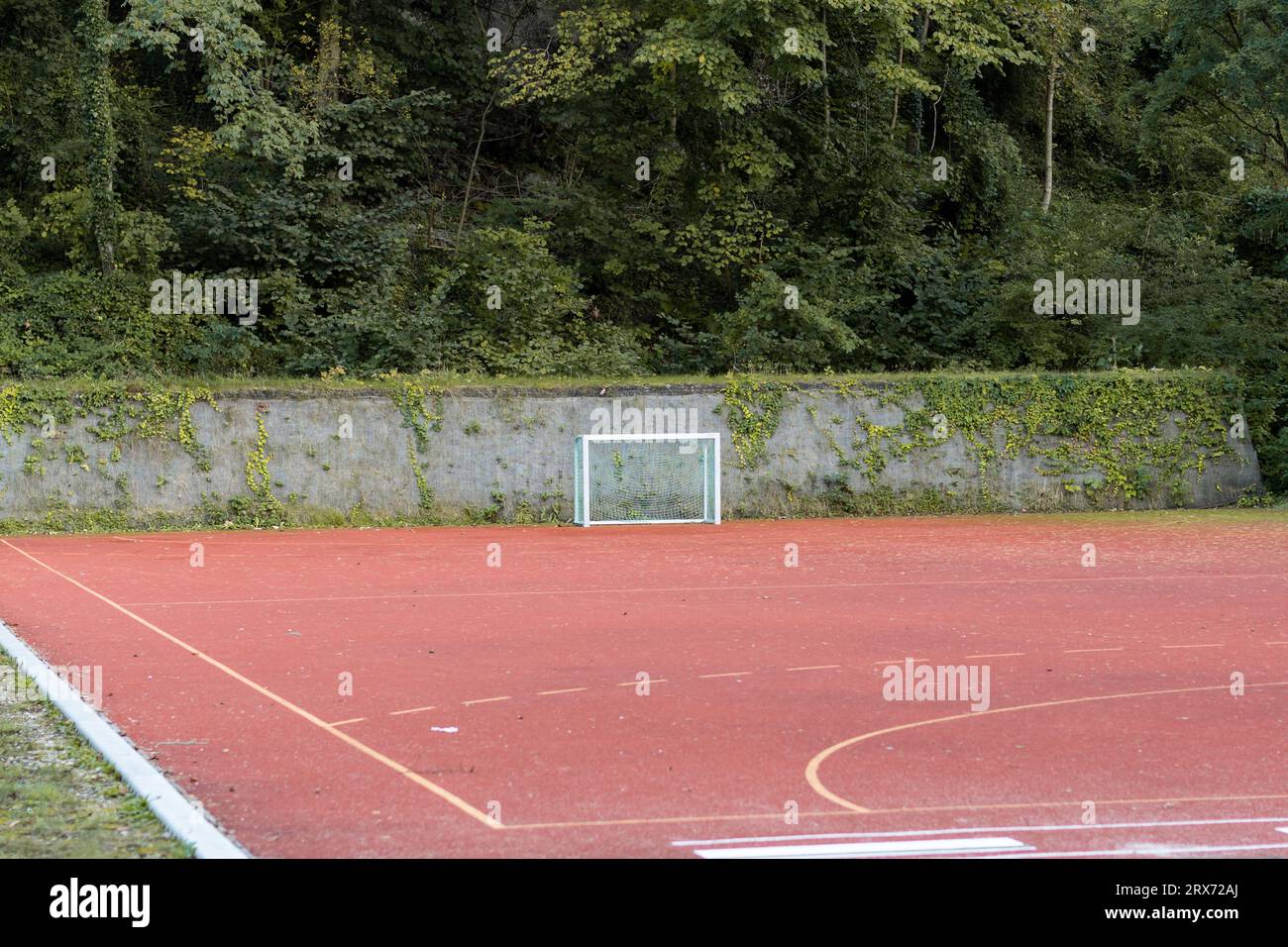 Kleines Hockeytor auf einem leeren Sportplatz. Der Polyurethanboden wird auch als Tartan-Material bezeichnet. Spielplatz für Freizeitaktivitäten. Stockfoto