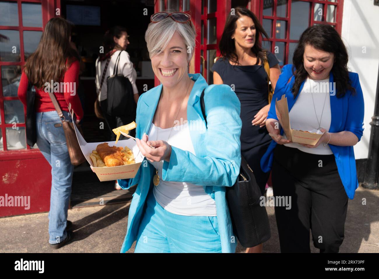 Daisy Cooper , stellvertretende Vorsitzende von LibDem , wird am ersten Tag der Liberaldemokraten-Konferenz von Parlamentskandidaten für Fish and Chips am Meer in Bournemouth begleitet . Bilddatum: Samstag, 23. September 2023. Stockfoto