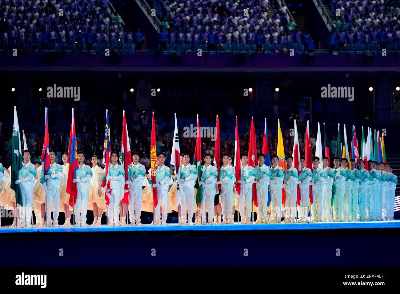 Performers hold the flags of the participating countries during the opening ceremony of the 19th Asian Games in Hangzhou, China, Saturday, Sept. 23, 2023. (AP Photo/Vincent Thian) Stockfoto
