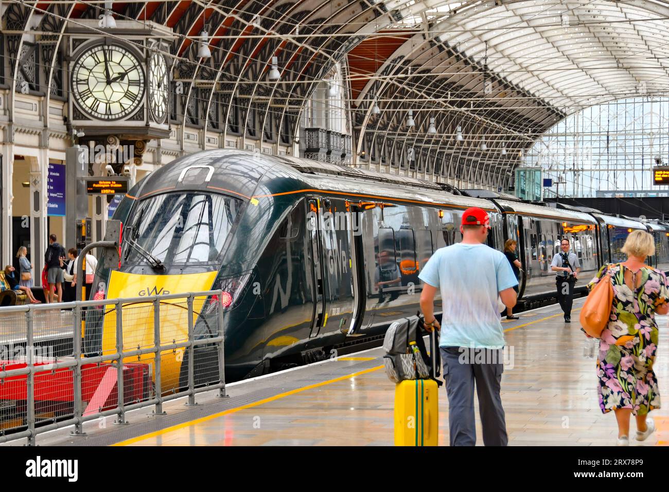 London, Enbgland, Großbritannien - 27. Juni 2023: Menschen gehen zu einem Hochgeschwindigkeitszug, der von der Great Western Railway am Bahnhof London Paddington betrieben wird Stockfoto