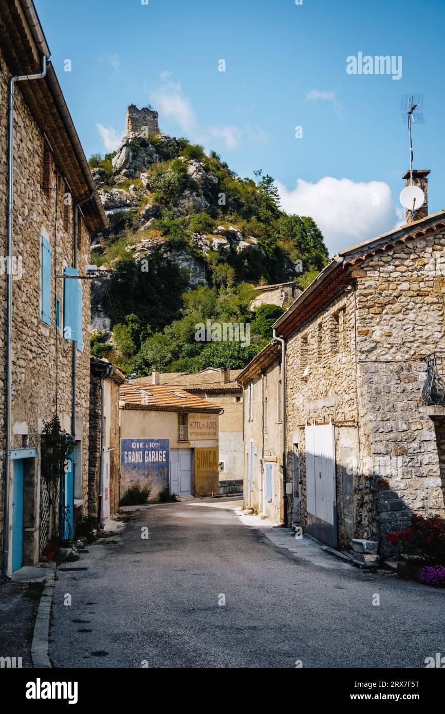 Enge Straße mit traditionellen Steinhäusern mit einer alten Anzeige und einem mittelalterlichen Kerker auf einem Hügel in Pontaix, in Drome (Südfrankreich) Stockfoto