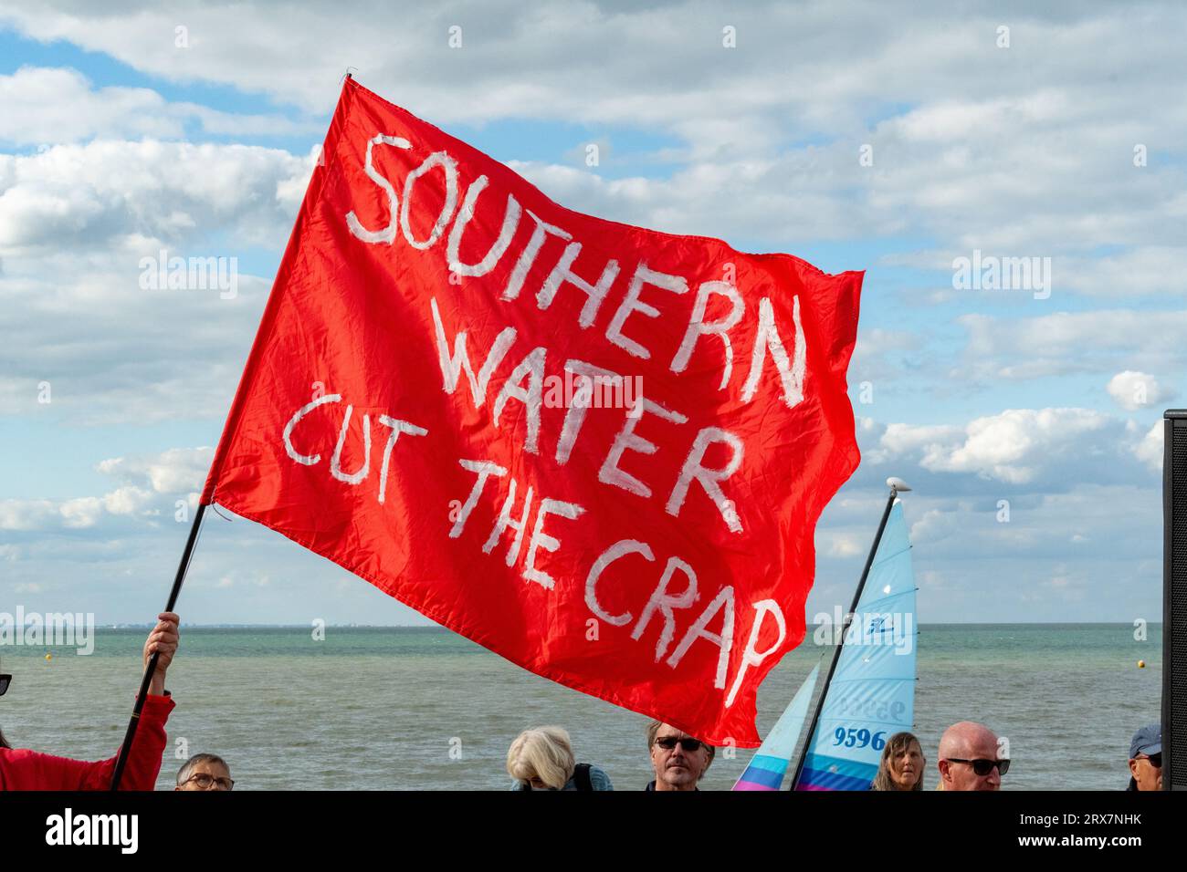 Eine rote Flagge mit der Aufschrift „SOUTHERN WATER CUT THE MIST“, die von einem Demonstranten beim SOS Whitstable-Protest über die Freisetzung von Abwasser aus dem südlichen Wasser in das Meer gehalten wurde. Stockfoto