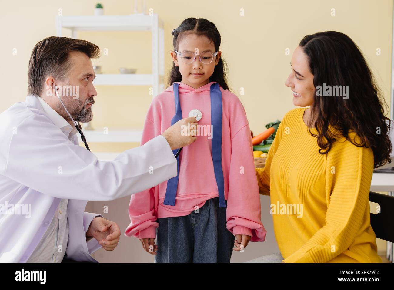 Mutter mit Tochter trifft Kinderärztin in der Klinik für Gesundheitscheck und spricht über psychische Probleme. Stockfoto