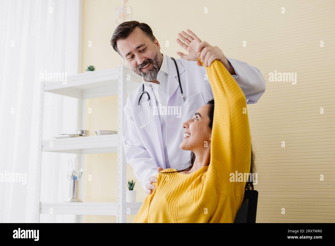 Patient Frau Armmuskelschmerzen Treffen Sie Senior Arzt für Physiotherapie Heilung und Erholung zurück gut arbeiten und sie sehr glücklich Stockfoto