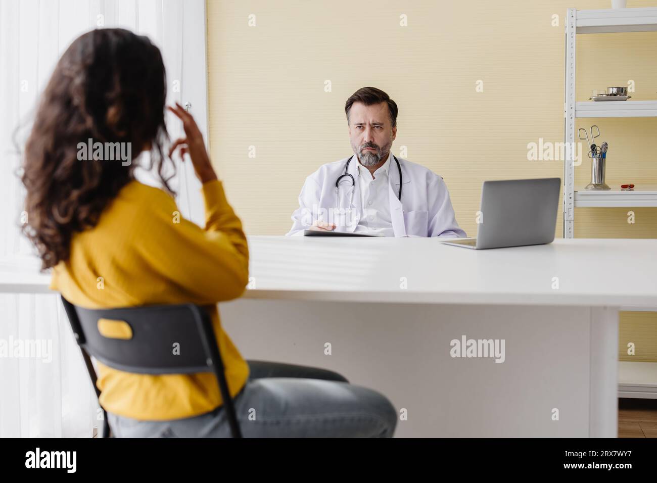Ängstliche, stressige Frau fühlt Kopfschmerz durch psychische Probleme beim Sprechen, konsultieren Sie den Arzt in der psychiatrischen Klinik Stockfoto
